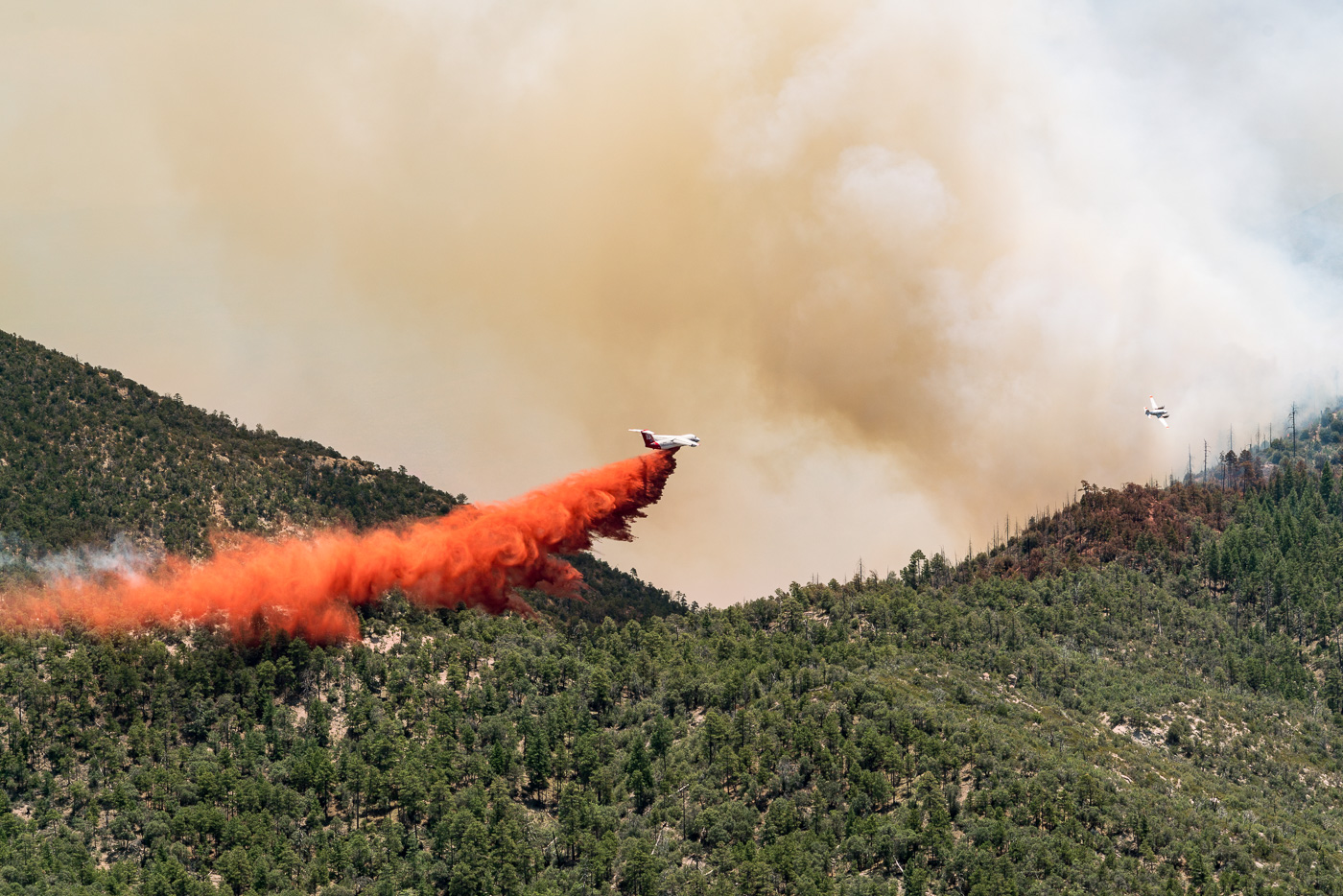 Airplanes drop fire retardant on flames trying to come over a ridge - near Guthrie Mountain. July 2017.