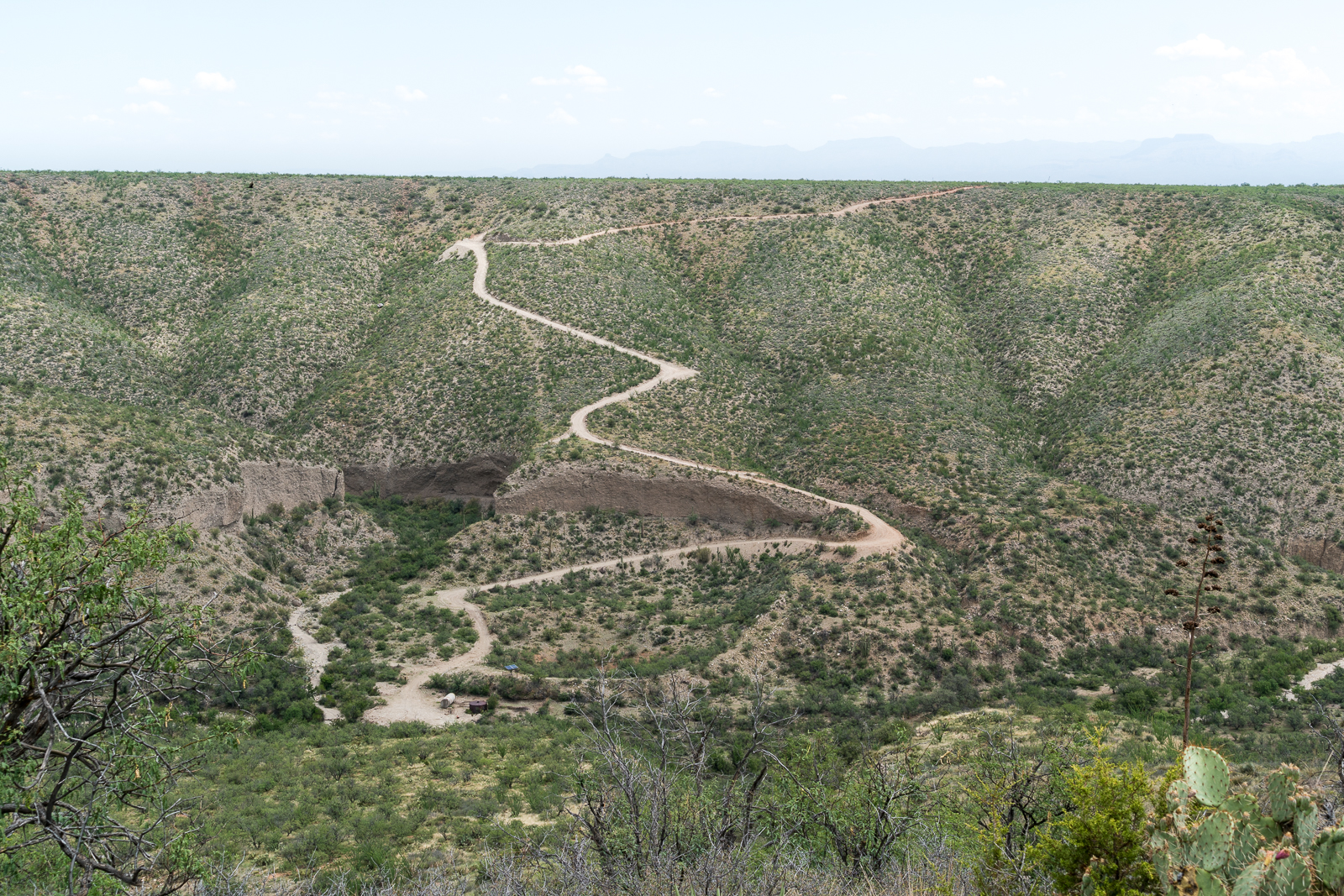 The road off the Black Hills Mine Road down into the bottom of Alder Canyon and to the Ventana Windmill - the tank and solar panels that power the pump that replaced the windmill are visible in the bottom of the canyon. July 2016.